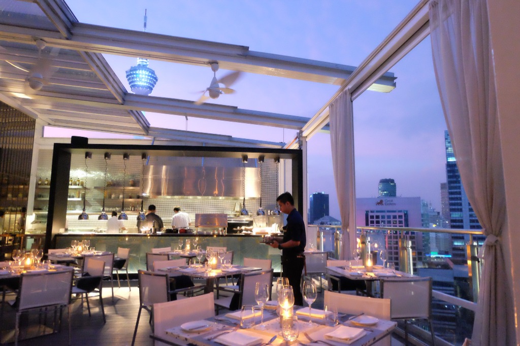 Chef preparing meals with KL Tower view